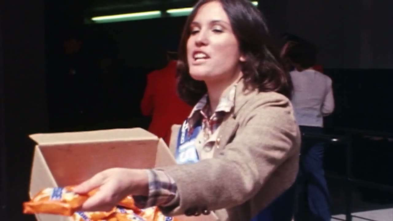 A stadium attendant in 1978 handing out orange-wrapped REGGIE! Bars from a cardboard box at the gate